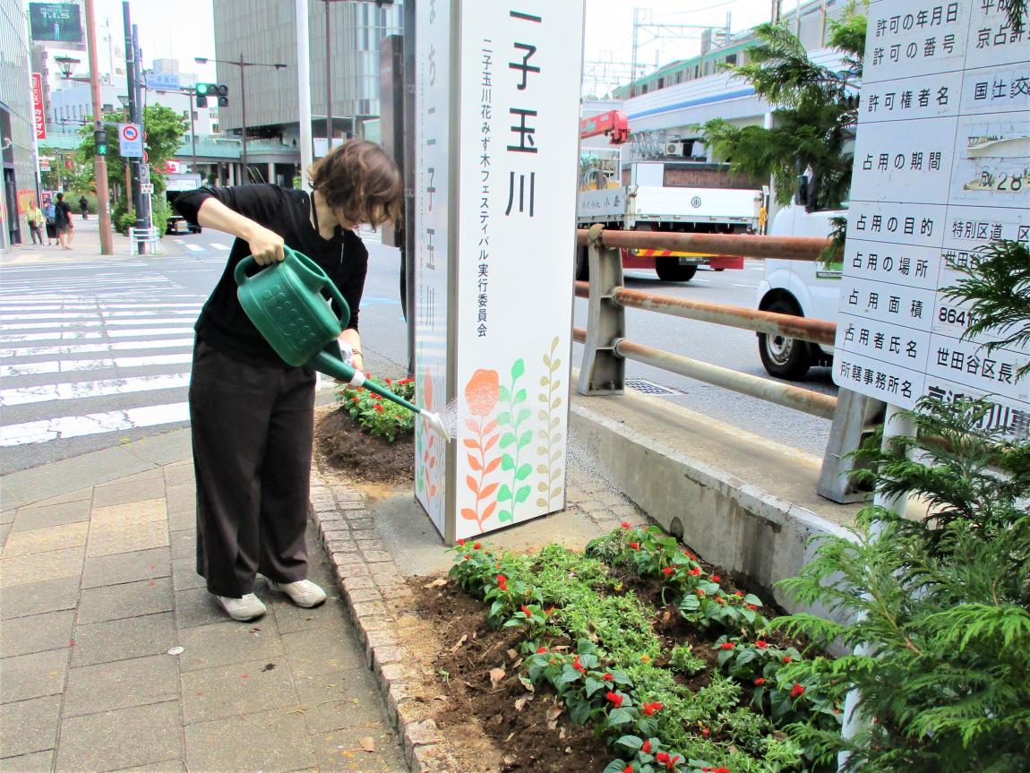 お花を植え終えた花壇にじょうろを使い、お水をやっている。