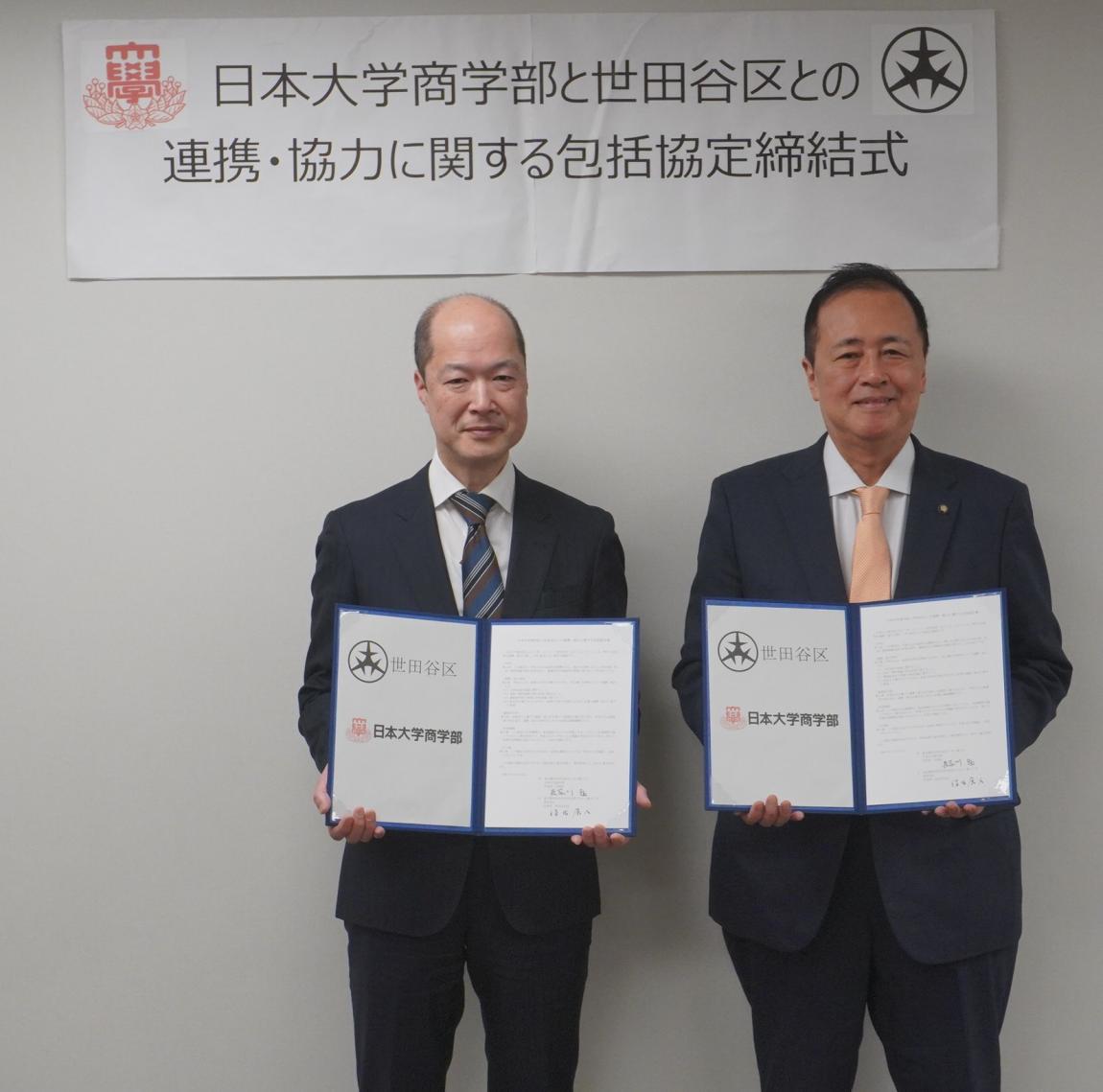 協定書を持つ学部長と区長