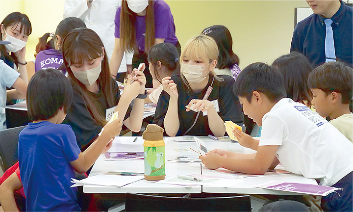 子どもたちと話す大学生の写真