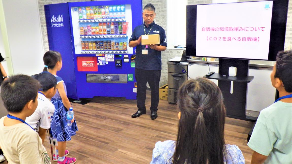 アサヒ飲料講座1「環境配慮型の自動販売機の見学をしている様子」